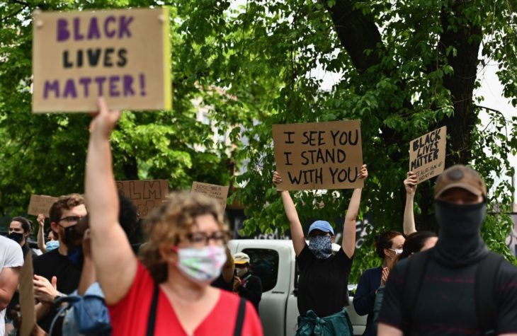 defund Protesters hold up signs on June 3, 2020