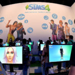 Visitors try out the game 'SIMS 4' at the Electronic Arts stand at the 2014 Gamescom gaming trade fair (Photo by Sascha Steinbach/Getty Images)