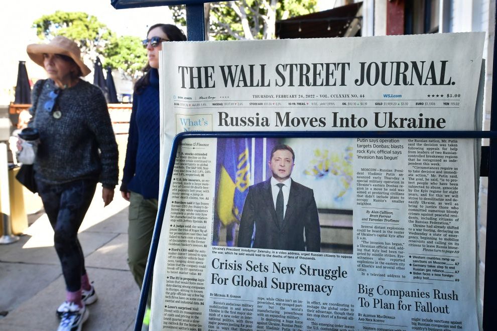 Pedestrians walk past a newspaper stand with copies of The Wall Street Journal (Photo by FREDERIC J. BROWN/AFP via Getty Images)